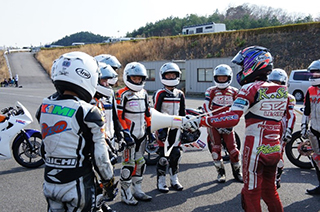 第1回目は、坂田校長も新規生へのアドバイスためCBR150Rクラスを指導。アカデミーでは、MotoGP解説では見られない?厳しい顔です。 リスクのあるスポーツなので、コースに入ったときは、より厳しい指導が求められます。子供たちのキリッと引き締まる顔が印象的。